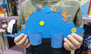Chłopiec prezentuje zrobionego niebieskiego dinozau